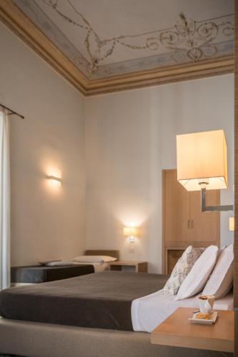 a hotel room with two beds and a lamp at Hotel Vittorio Veneto in Ragusa