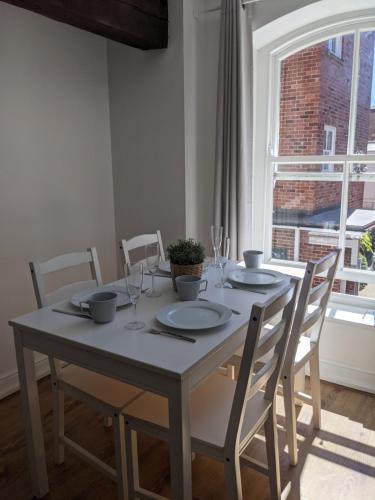 a dining room table with chairs and a large window at Riverside Apartment York in York
