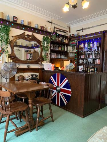 a bar with a wooden table and a mirror at The George Guest House in Bridlington