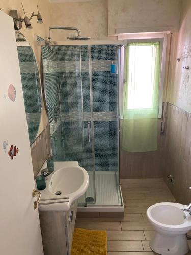 ein Bad mit einer Dusche, einem Waschbecken und einem WC in der Unterkunft E&C Suites Roma in Lido di Ostia