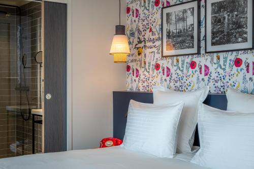 a bedroom with a bed with white pillows at Ferdinand Hotel Tours in Tours