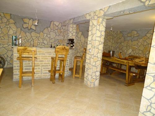a room with wooden chairs and a stone wall at Zana Apartments in Stan Trigraci