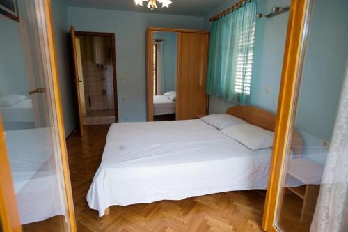 een slaapkamer met een wit bed en een spiegel bij 2-bedroom Apartment with terrace in Povile 3542-1 in Povile
