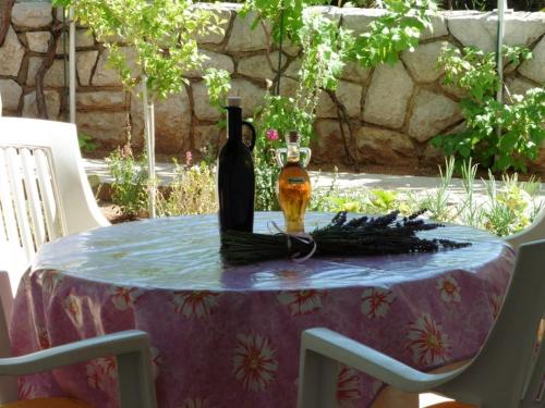 a table with two bottles of wine on it at Apartment in Punat with Terrace, Air conditioning, Wi-Fi, Washing machine (3829-2) in Punat