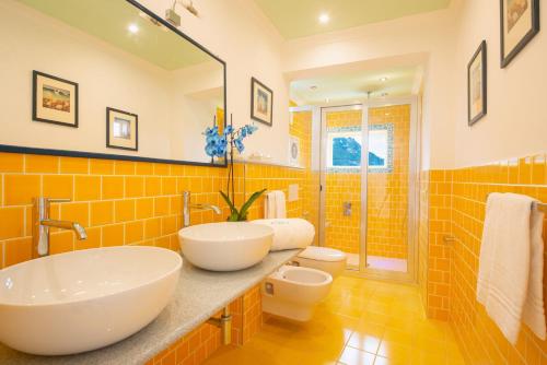 a bathroom with two sinks and a shower at Hotel Villa Bianca in Ischia