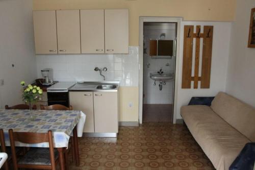 eine Küche und ein Wohnzimmer mit einem Tisch und einem Sofa in der Unterkunft Apartment Garden (112-3) in Medulin