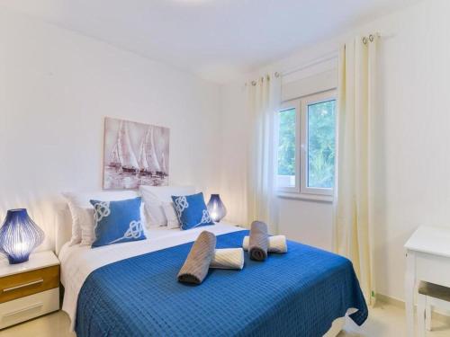 Un dormitorio con una cama azul y blanca con toallas. en Apartmani Velić, en Vir
