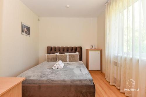 a bedroom with a large bed with two shoes on it at Palanga 777 - poilsio namai prie Birutės parko ir jūros in Palanga
