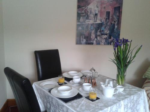una mesa de comedor con un mantel blanco. en Manor Garden Lodge, en Wirral