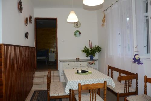 a dining room with a table and some chairs at Téli Berek Vendégház in Abod