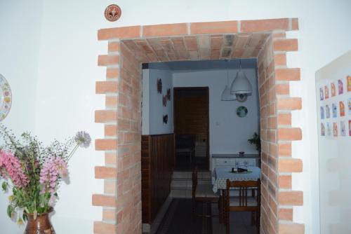 a room with a brick wall and a hallway at Téli Berek Vendégház in Abod