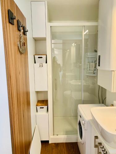a white bathroom with a glass shower in it at mariTIME deluxe in Portorož