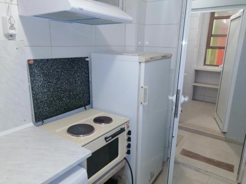 uma pequena cozinha com um fogão e um frigorífico em Къща за гости Диана ДИК em Kiten