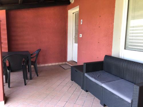 a patio with a table and chairs and a bench at Residenza le Saline in Comacchio