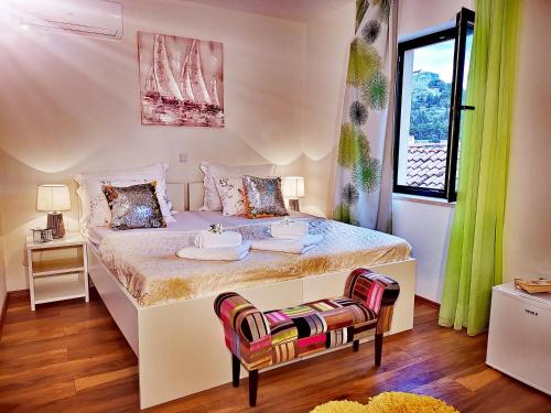 a bedroom with a large white bed and a chair at Apartments Ante 2 in Hvar