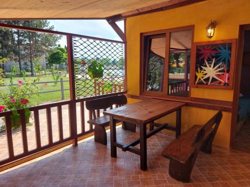 een veranda met een houten tafel en een bank bij Villa art colony in Ohrid