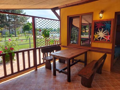 a porch with a wooden table and a bench at Villa art colony in Ohrid