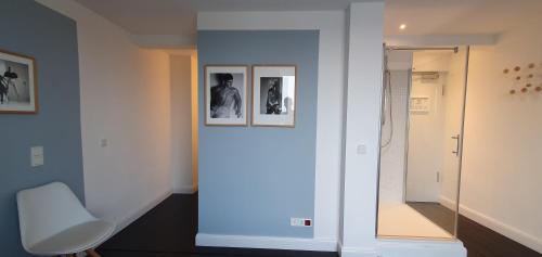 a hallway with a white chair and pictures on the wall at MAISON MARSIL - Boutique Hotel Köln in Cologne