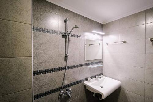 a bathroom with a sink and a shower and a mirror at Хотел ПИРГУЛЯ in Miladinowzi