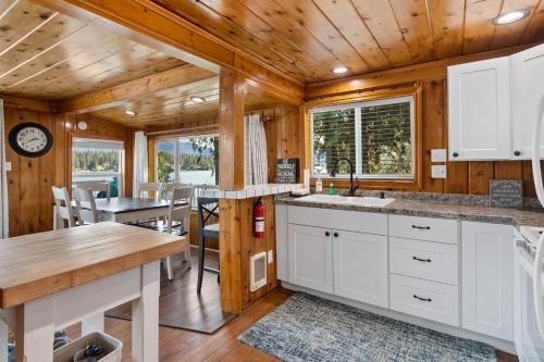 a kitchen with white cabinets and a dining room with a table at Lakeside Loungin' in Hayden