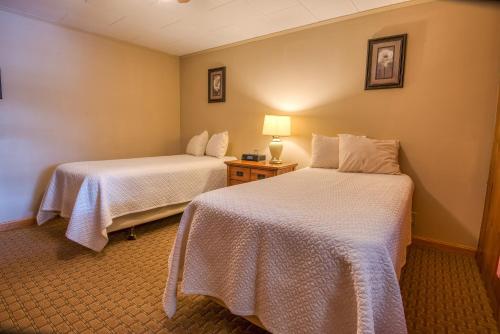 a hotel room with two beds and a table with a lamp at Purity Spring Resort in Madison