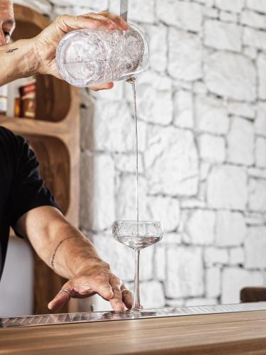 a person is pouring a glass of wine at Mykonos Earth Suites in Mýkonos City