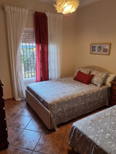 sypialnia z 2 łóżkami i oknem w obiekcie VACACIONES DE LUJO.CHALET PISCINA Y PLAYA.EL PUERTO w mieście El Puerto de Santa María