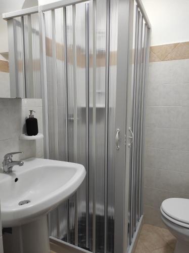 uma casa de banho com um chuveiro, um lavatório e um WC. em Apartment Casa Felice em Ostuni