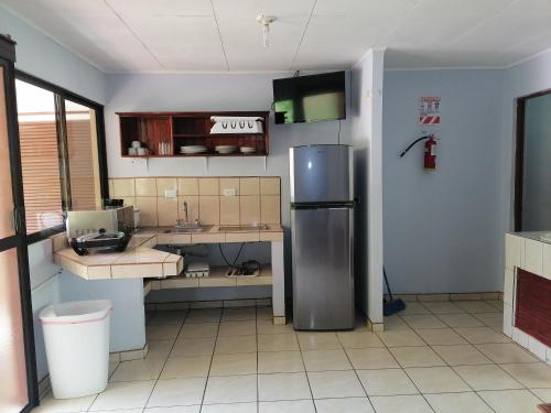 uma cozinha com um lavatório e um frigorífico em Centro Vacacional Bancosta em Jacó