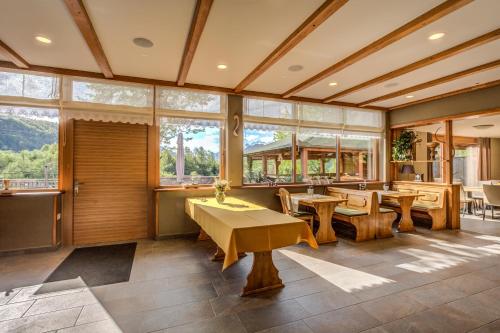 a dining room with tables and chairs and windows at Tourist Farm Kranjc in Kobarid