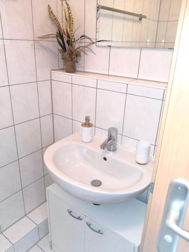 a white bathroom with a sink and a mirror at Appartement Bahnhof in Mainz