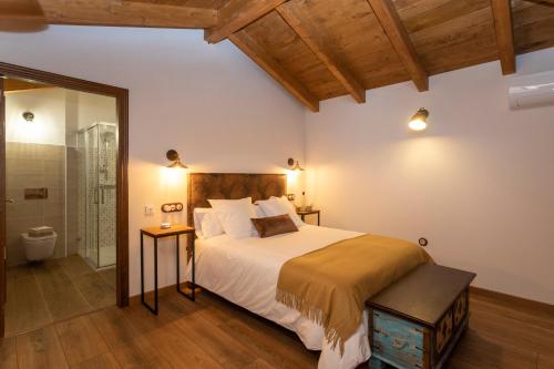 a bedroom with a large bed and a bathroom at Araucaria House in Barreiros