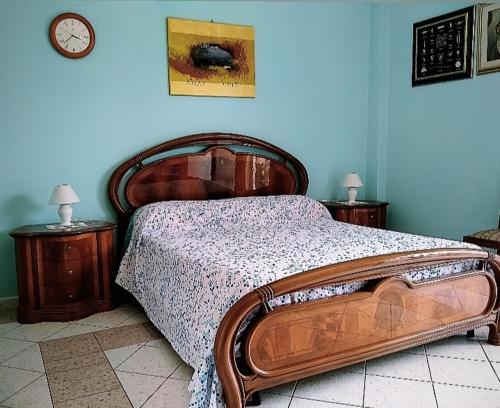 ガリポリにあるBuonanotte Gallipoliのベッドルーム1室(木製ベッド1台、ナイトスタンド2台付)