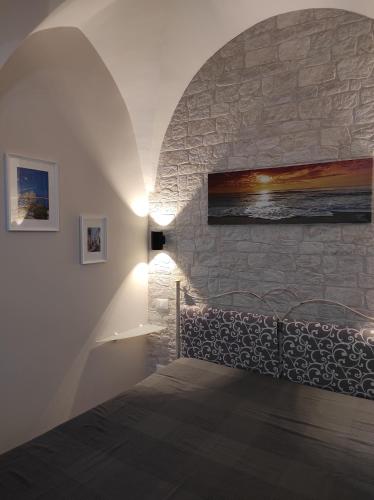 a bedroom with a bed with a stone wall at Apartment Casa Felice in Ostuni
