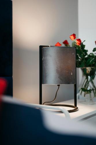 a computer monitor sitting on a desk with a vase of flowers at Nocosfera Apartament Serbinów in Kalisz