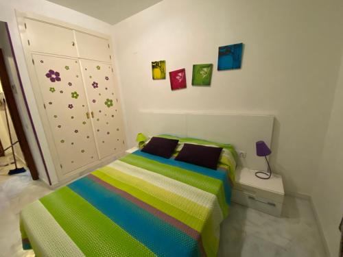 ein Schlafzimmer mit einem Bett mit einer bunten Decke in der Unterkunft APARTAMENTO Centro ciudad in Jerez de la Frontera