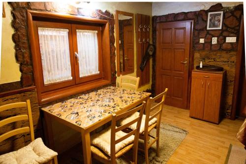 a dining room with a table and chairs and a door at Smeštaj Popović in Perućac