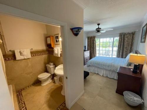 a bathroom with a bedroom with a bed and a toilet at Coconut Cove Resort & Marina in Islamorada