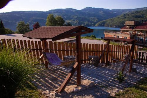 a wooden deck with a chair and a gazebo at Smeštaj Popović in Perućac