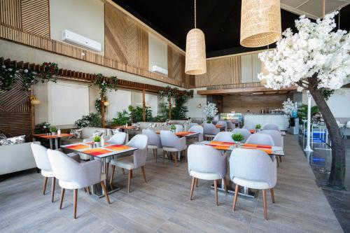 a dining room with tables and white chairs at Sea Gull Marina Hotel in El Alamein