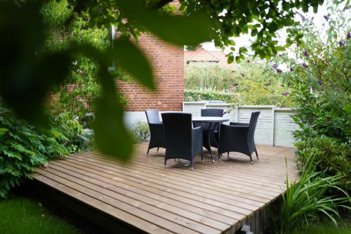 a table and chairs sitting on a wooden deck at Comfortable Large Room King S bed near CPH centre in Copenhagen
