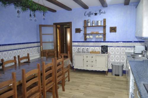 a dining room with blue walls and wooden chairs at El Capricho de los Carrascos in Juarros de Voltoya
