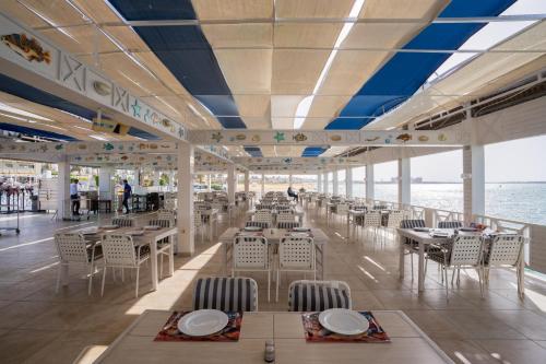 a restaurant on a cruise ship with tables and chairs at Sea Gull Marina Hotel in El Alamein