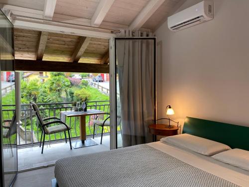 a bedroom with a bed and a balcony with a table at Apartment Gisa in Colazza