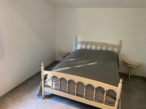 une chambre avec un lit en bois dans une pièce dans l'établissement petit coin de paradis en camargue entre Aigues mortes et les saintes maries de la mer, animaux bienvenus, à Vauvert