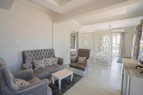 a living room with a couch and two chairs at Sea Gull Marina Hotel in El Alamein