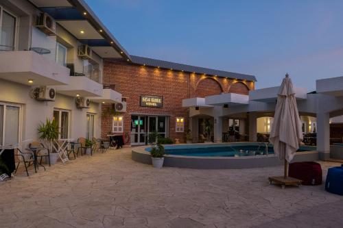 a hotel with a pool and a patio with an umbrella at Sea Gull Marina Hotel in El Alamein