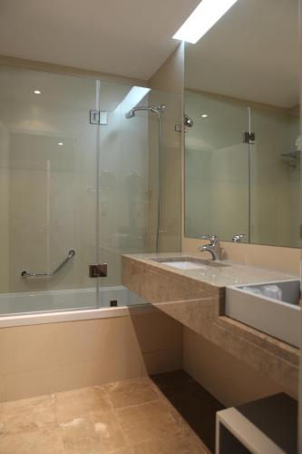 a bathroom with a sink and a mirror and a tub at Hotel Anjo de Portugal in Fátima