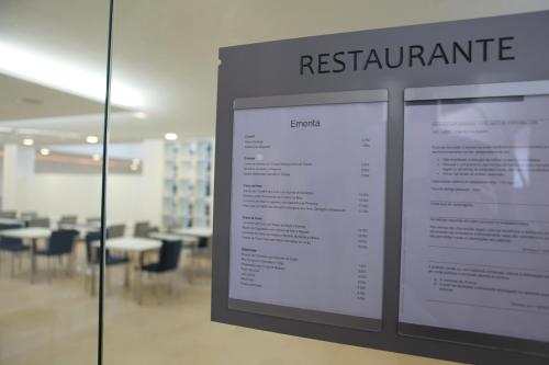 a sign for a restaurant in a room with tables at Hotel Anjo de Portugal in Fátima