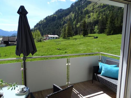 a balcony with an umbrella and a view of a field at Ferienwohnungen Apart Diana in Vils